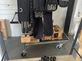 un porte-chaussures sur lequel sont suspendues plusieurs paires de bottes et une paire de chaussures