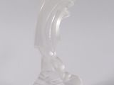 a clear plastic sculpture of a wave on a white surface