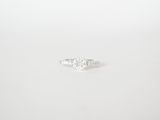 a close up of a diamond ring on a white surface