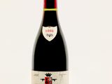 une bouteille de vin rouge posée sur une table blanche