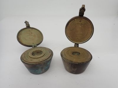 deux petits récipients métalliques posés sur une surface blanche
