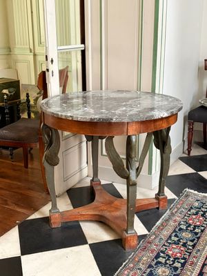 une table au plateau en marbre, placée au milieu d'une pièce