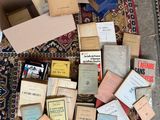 une pile de vieux livres posée par terre à côté d'une boîte