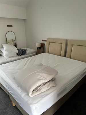 deux lits dans la chambre, recouverts de draps blancs