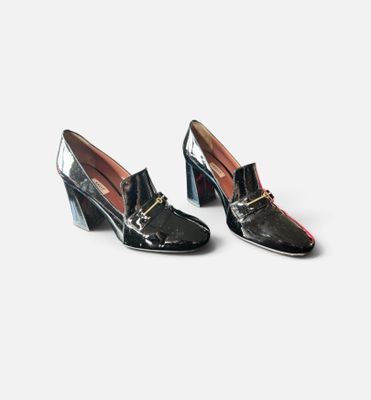 une paire de chaussures noires avec une boucle dorée au talon