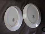 two white plates sitting on top of a table