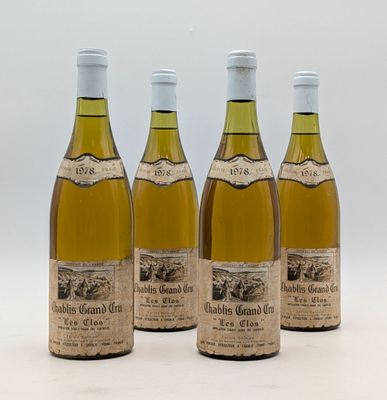 quatre bouteilles de vin sont alignées sur une surface blanche