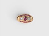 gros plan d'une bague en or avec un rubis et des diamants
