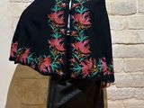 woman wearing a black cape with colorful flowers on it