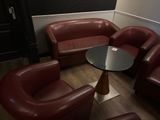 des fauteuils en cuir et une table dans une pièce aux murs noirs