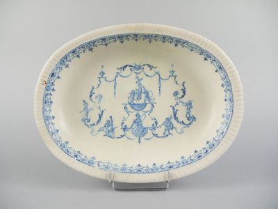 plat ovale bleu et blanc orné d'un motif de fleurs et de vrilles