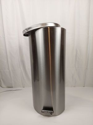 une poubelle en acier inoxydable posée sur une table blanche