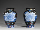 pair of vases with blue and white flowers on a black background