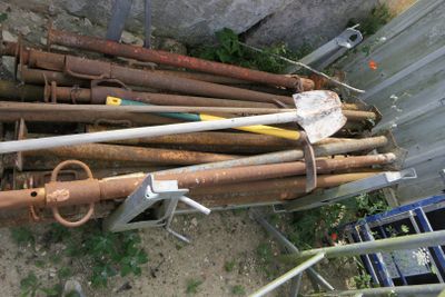 un tas de vieux tuyaux rouillés et d'autres outils dans la cour