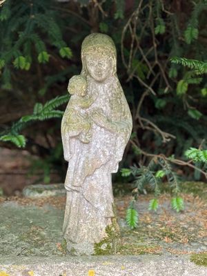 une statue de femme tenant un bébé dans ses bras