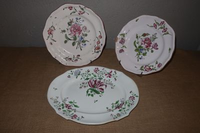 trois assiettes ornées de fleurs, posées sur une table