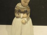 une figurine représentant une femme tenant un ours en peluche