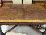 a wooden table with chairs around it in a room