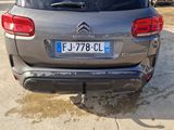 the rear end of a silver car parked in front of a building