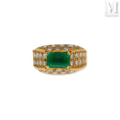 un gros plan d'une bague sertie d'une émeraude entourée de diamants