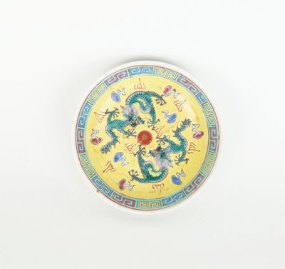 a yellow plate with a dragon on it on a white surface