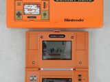 an orange nintendo game and watch with a game screen on top of it