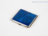 silver and blue glass business card case on a white surface