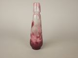 a pink glass bottle with a red swirl on it