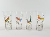 four glasses with birds painted on them sitting on a white surface