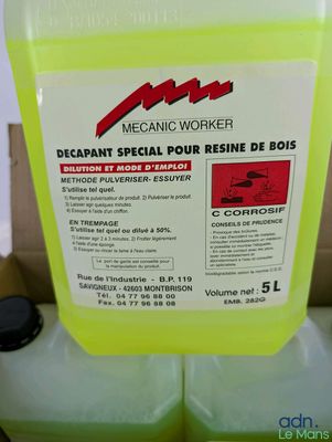 un récipient jaune rempli de liquide posé sur une boîte en carton
