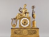 une horloge en or avec une femme assise dessus