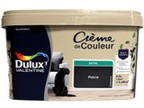 un pot de peinture à côté duquel est assis un chat noir