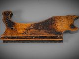 an old wooden comb with rust on it sitting on a table