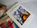 a book that is sitting on top of a pile of quilts