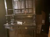 a black cabinet and a chair in the corner of a room