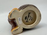 a ceramic figurine of a dog with a tag on it