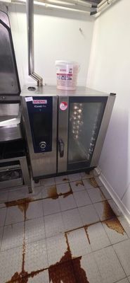 a dirty floor in a kitchen with a microwave and oven