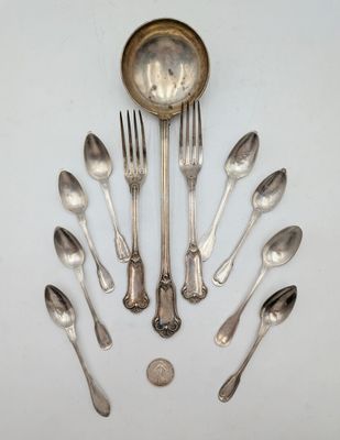 un grand nombre de cuillères et de fourchettes en argent disposées en cercle
