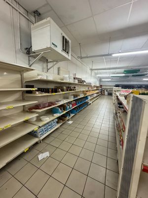 de nombreuses étagères vides dans un magasin, posées à même le sol