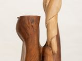 a wooden sculpture of a man and a woman sitting on a table