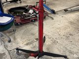un présentoir rouge et noir sur lequel est accrochée une affiche, dans un garage