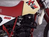a red and white dirt bike parked in a garage