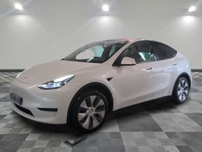 the white tesla suv is parked on a checkered tile floor