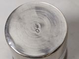 a small silver container sitting on a white surface