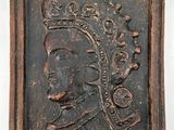 a close up of a wooden plaque with a man wearing a crown