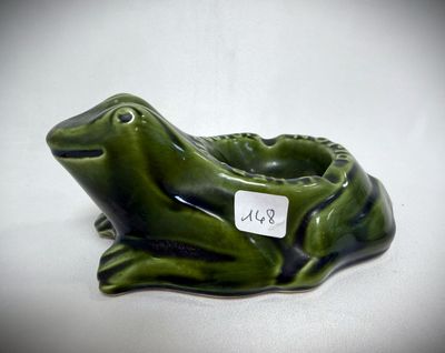an image of a green frog figurine sitting on a white surface