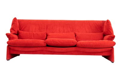 Le canapé rouge est posé sur un sol blanc, avec des coussins.