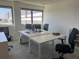 a white desk with two computers on it in an office