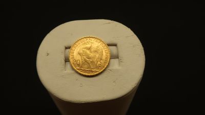 an image of a gold coin sitting on top of a white object