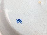 a close up of a white plate with a blue symbol on it